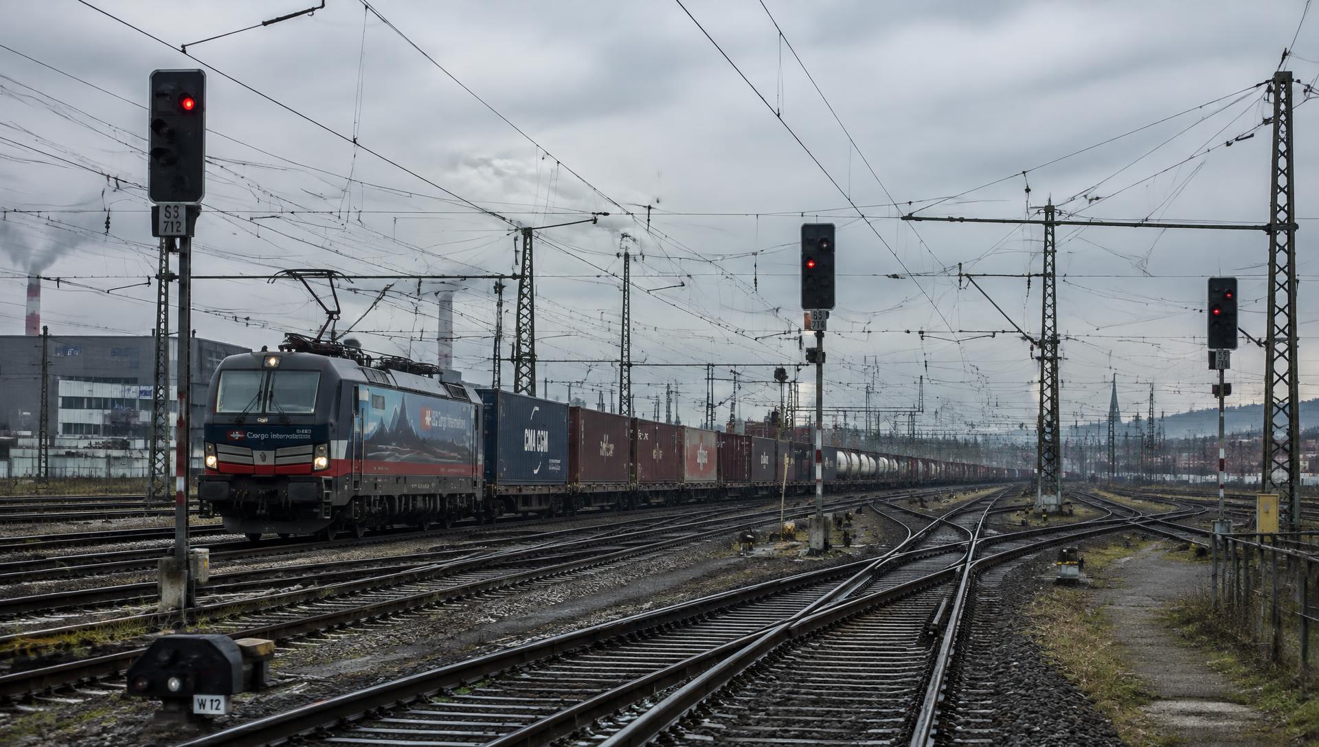 Freight train on a rail junction with signalling equipment